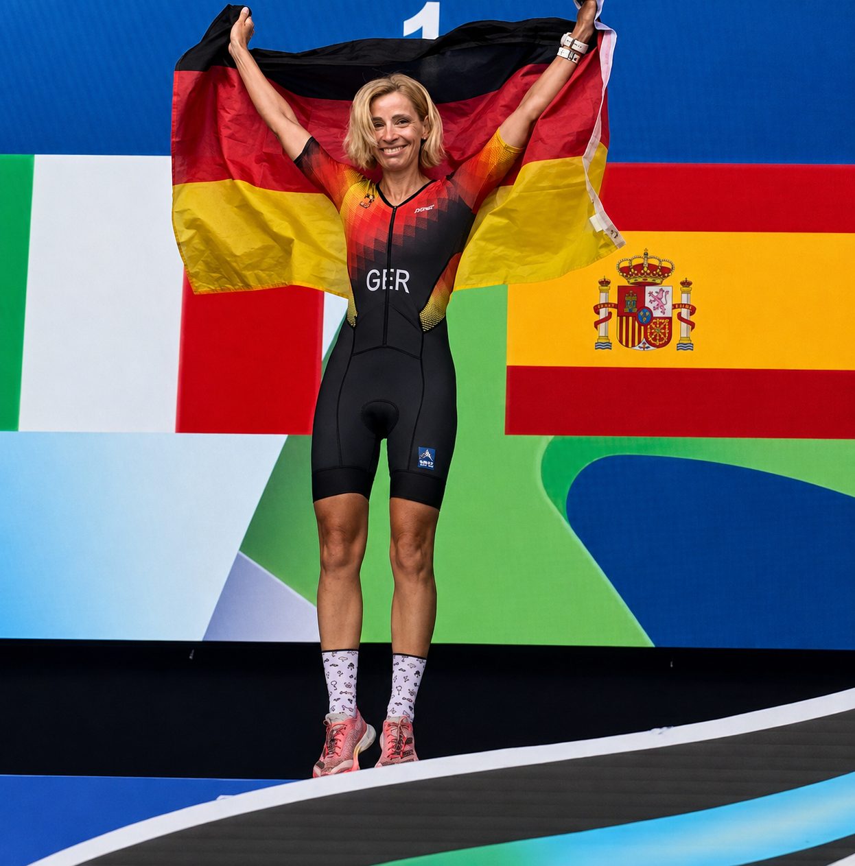 Manuela S&uuml;&szlig; auf dem Siegerpodest mit Deutschland-Flagge